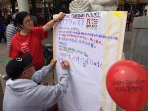 Two people write down thoughts about what they think Chinatown's future should be.