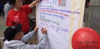 Two people write down thoughts about what they think Chinatown's future should be.