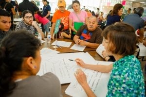 Houston residents gather around a large table to discuss ideas to improve their neighborhood.