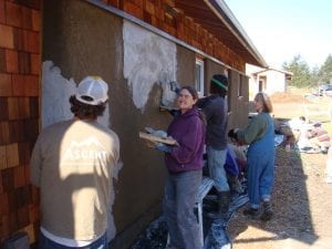 Ccontractor, resident, interns and volunteers worked together to put on a lime coat on the straw-bale wall. 