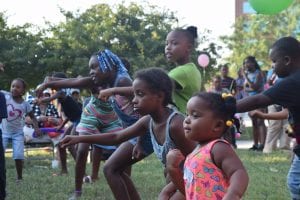 Young African-American children work out together in a park-like setting.