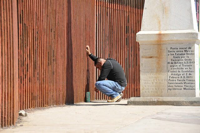 man at border fence