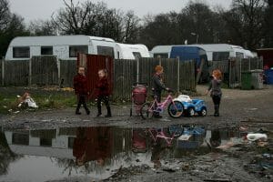 Children play on an Irish Traveller site on Dale Farm in 2011. A young boy with glasses rubs his eyes outside in Dale Farm, which was once the site of the largest Irish Traveller concentration until families were evicted in 2011. A health impact assessment helped house this indigenous group.