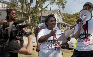 Kennetha Patterson of Homes for All in Nashville speaks on a megaphone during Renter’s Week of Action.