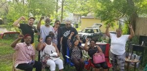 North Minneapolis tenants pose together with their fists in the air during a barbecue
