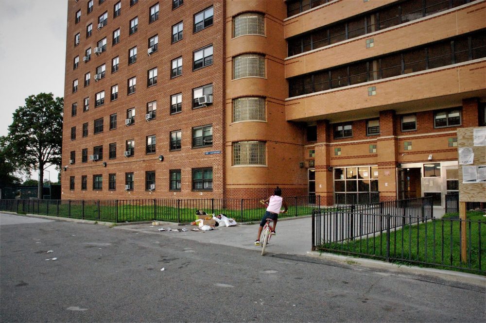 A child rides her bike outside of Ocean Bay (Bayside) Apartments in Far Rockaway, the first housing project in New York City to take part in the RAD program, as well as the largest RAD-funded project in the country.