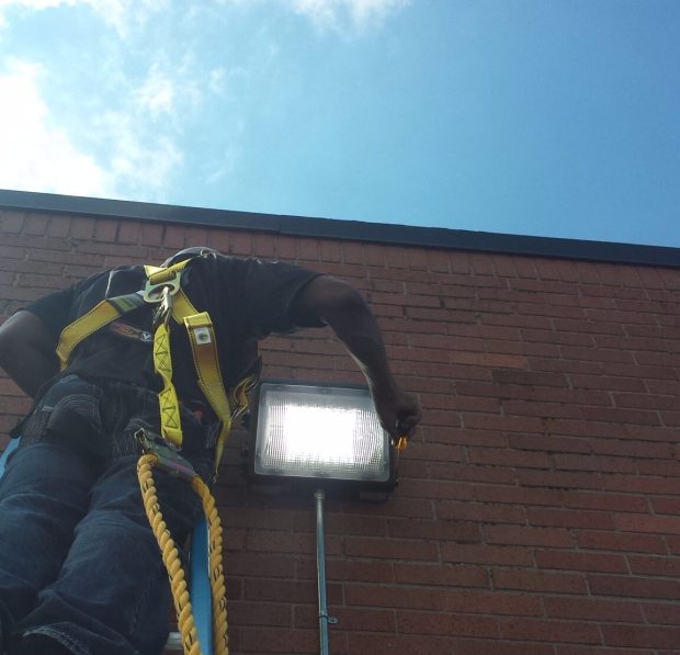 An OWN Rochester team member works on an and LED lighting installation.