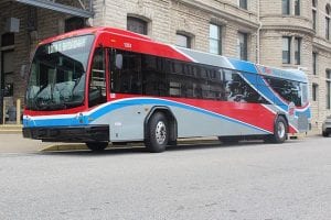 A blue, red, white, and gray bus. The cost of a bus ride is a pretty good deal for a penny-conscious nonprofit business traveler, but conferences tend not to include information about bus routes.