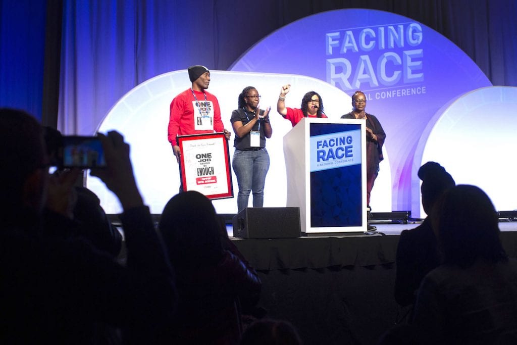 Four people on a stage during the Facing Race conference, which in 2018 negotiated a community benefits agreement with local leaders.