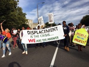 Boston residents participants marched to a nearby national gathering of YIMBYs with a sign that reads "Displacement is the Crisis ... We Are The Answer."