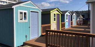 Six tiny houses share a common deck.