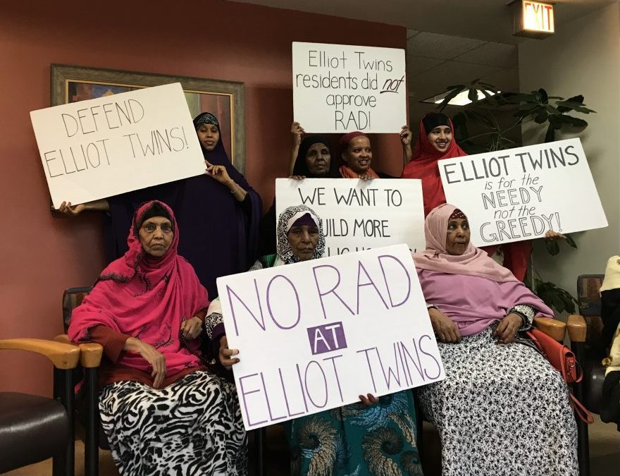 Women hold up signs that read "No RAD at Elliot Twins" and others.