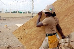 Woman construction worker carrying wood