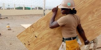 Woman construction worker carrying wood