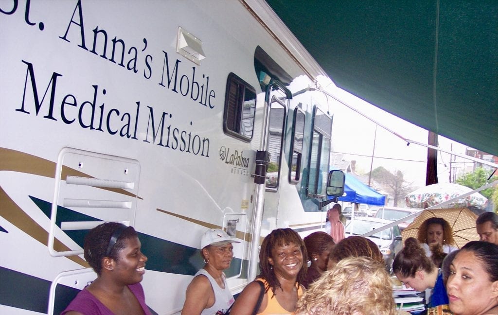 Residents stand if front of St. Anna’s medical RV.