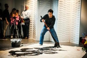 man painting canvas on floor