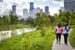 Parks can be a key component of building resilience. Two women walk adjacent to Buffalo Bayou Park in downtown Houston, Texas.