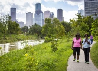 Parks can be a key component of building resilience. Two women walk adjacent to Buffalo Bayou Park in downtown Houston, Texas.