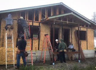 People work to build a home using an approach to create a passive house.