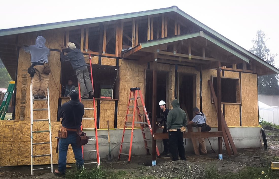 People work to build a home using an approach to create a passive house.