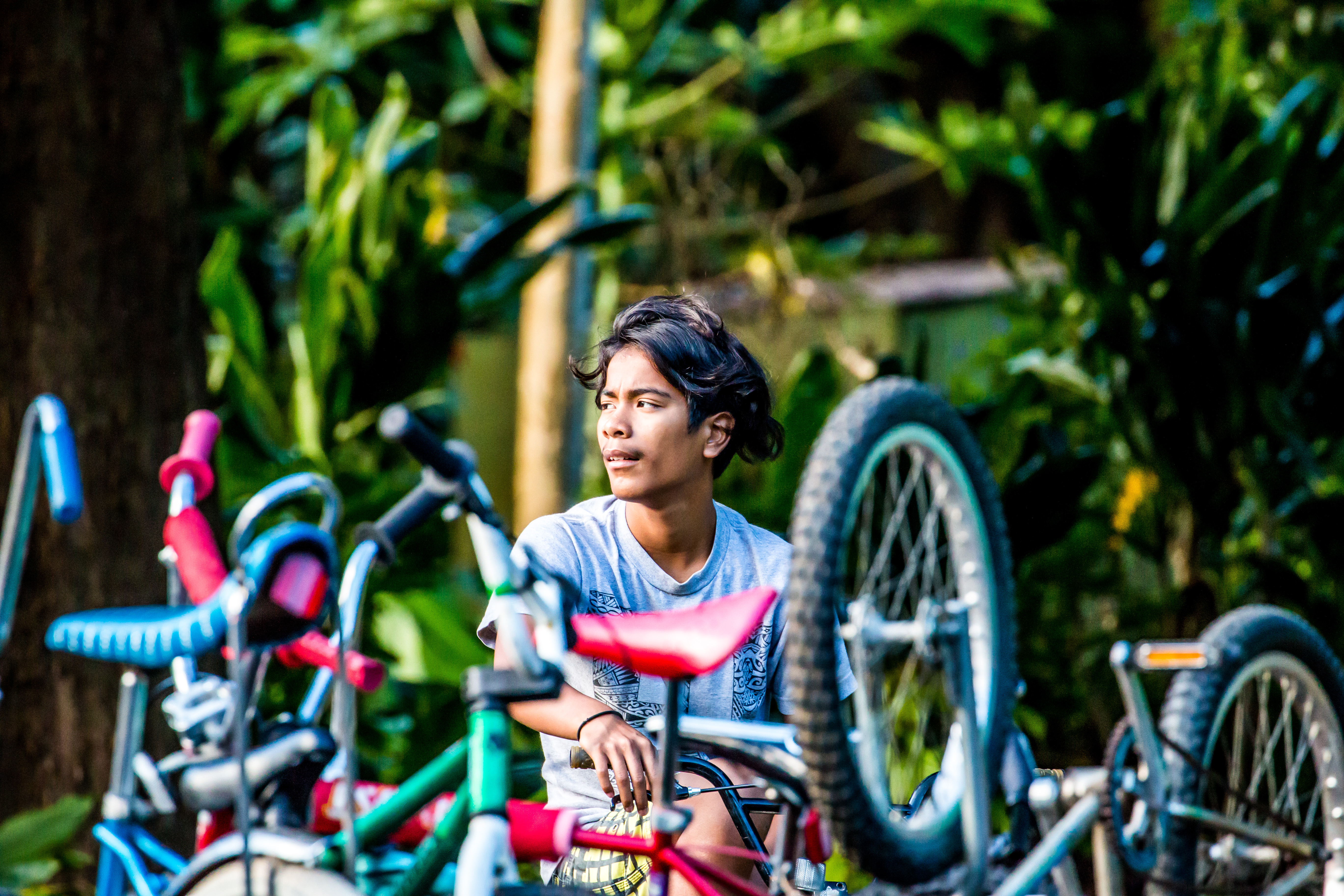 A young man repairs a bike as part of a program in Hawaii that offers young men and boys healing spaces.