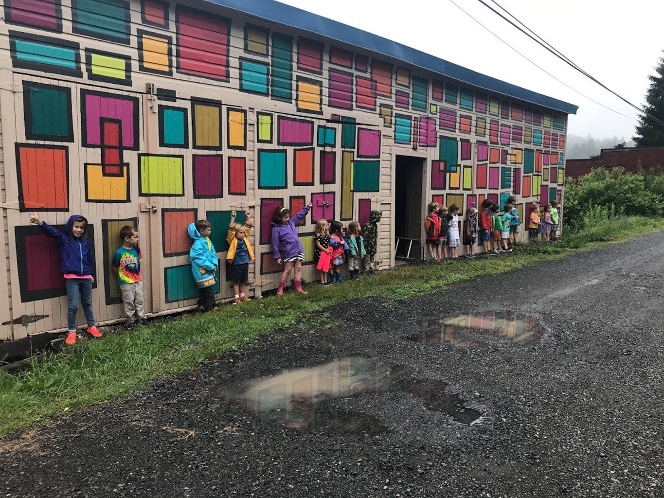 Kids stand in front of a mural in Thomas, West Virginia.