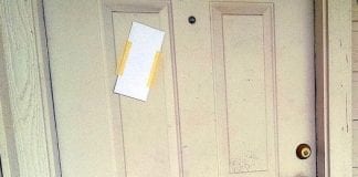 Eviction notice: door with envelope taped to it
