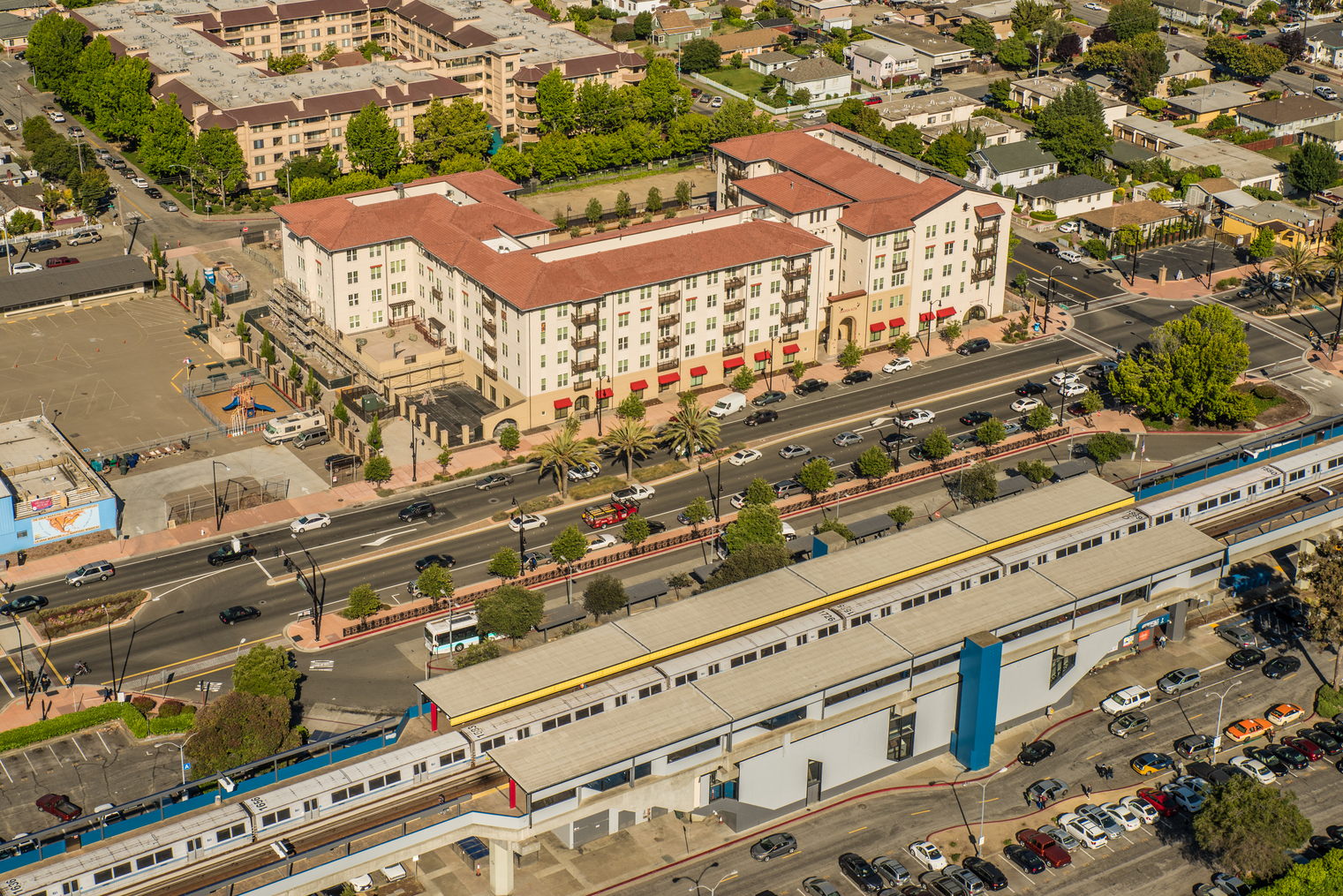 A 200 unit building was built on transit land in California. In front of the building is the San Leandro Bart Station. 