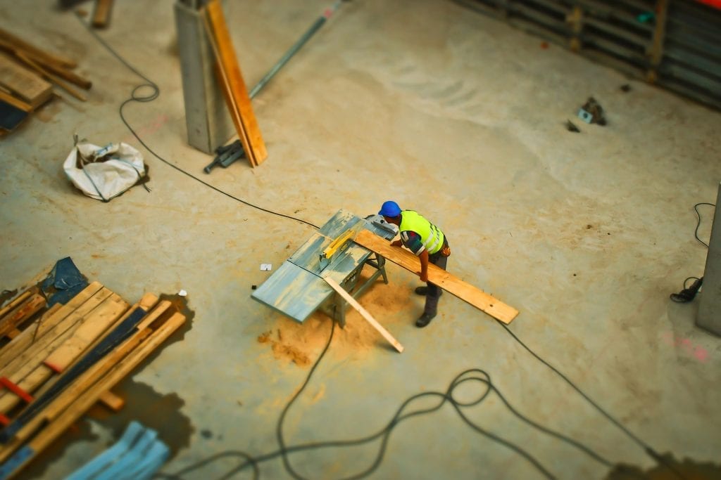 An aerial view of construction worker sawing board, an image shown to reflect community development funding for communities.