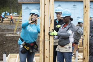 Habitat for Humanity volunteers work together framing a doorway.