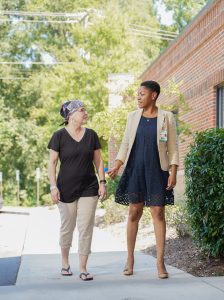 A doctor and her patient walk outside.