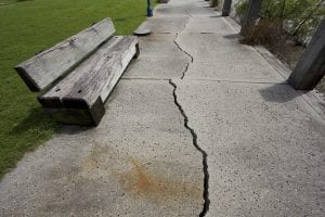 CRA reform, CRA. A view of a sidewalk that's cracked lengthwise. 