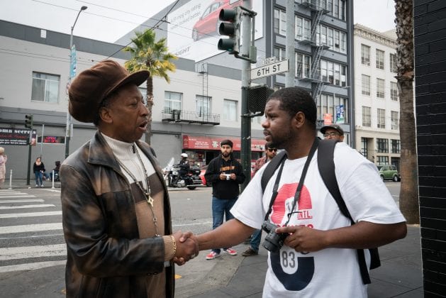 A man with a hat shakes the hand of a Visions of Justice student.