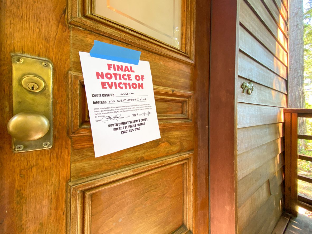 An eviction sign posted outside of a wooden door. Up to 23 million people could be evicted from their homes by September.