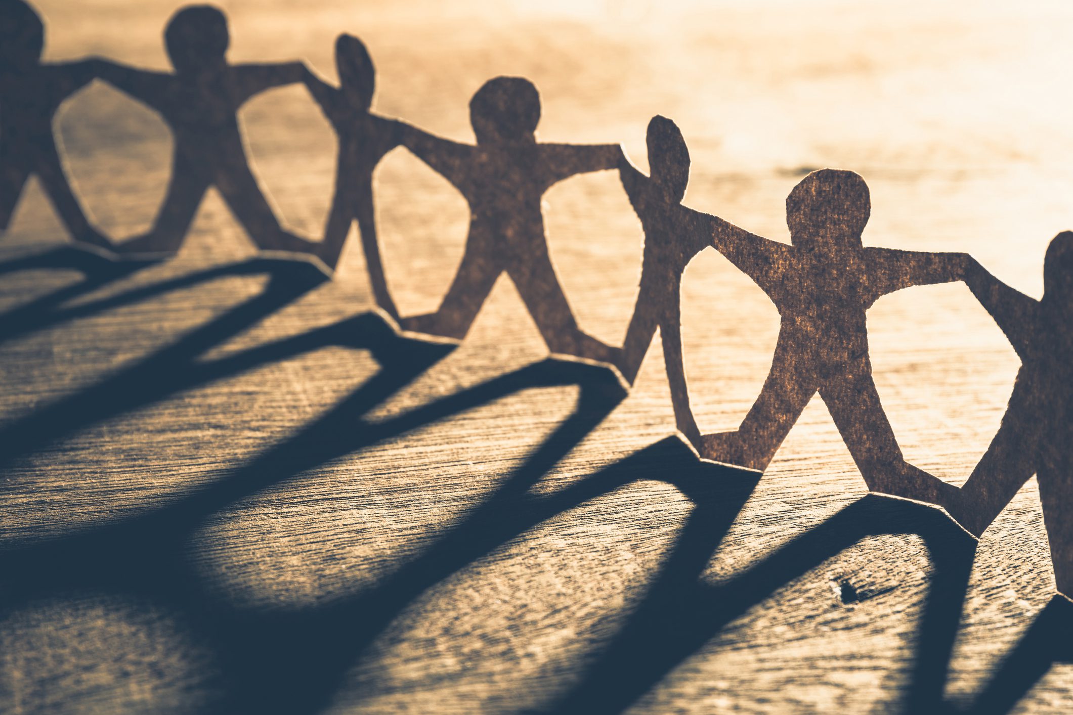 Human chain paper with light and shadow on wood table