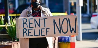 A protestor holds a "Rent Relief Now" sign during a North Carolina demonstration this month