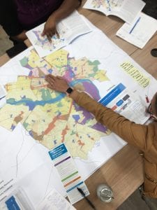 photo is view from above of hands pointing to maps as community engagement team discusses Richmond's future