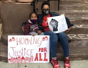 Emergency Services Grants. Photo shows a woman and her grandchild dremonstrating for housing court reforms in Albany, New York