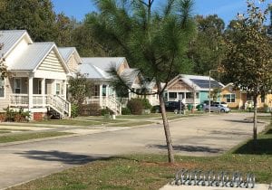 photo shows a row of pastel-colored cottages in the sunshine, to accompany an article about design for healthy affordable housing