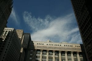 A view looking up toward the top of Chicago City Hall, with blue sky above it. Accompanying an article about the city's REIA and resulting new QAP.