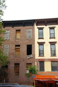 Image shows derelict row houses in New York, accompanying article about squatters