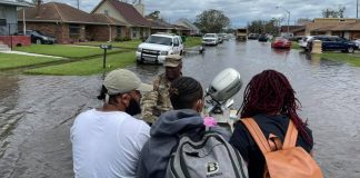 A National Guardsmen rescues three people on a boat in LaPlace, Louisiana,after Hurricane Ida brought flooding to the area.