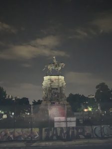 Nighttime photo of the Robert E. Lee equestrian statue on Monument Row in Richmond, Va. The base of the monument was the site of much street art in the protests following the murder of George Floyd