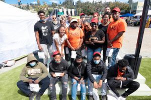 A group of people wearing orange and black shirts pose together for a photo.