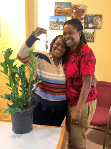 Illustrating an article on homeownership programs, photo shows two smiling people sharing a sideways hug as one of them holds up a key to their new house. 