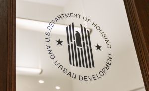 A glass door etched with a logo that reads "U.S. Department of Housing and Urban Development" in black. Changes HUD implemented in 2013 have made it harder for community housing development organizations, or CHDOs, to receive housing funds.