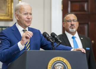U.S. President Joe Biden speaks at a White House podium.