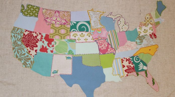 A patchwork map of the continental U.S., with a different fabric for each state. Some fabrics are solids, some prints, tending toward stylized florals. The state lines have been embroidered with contrasting thread colors.