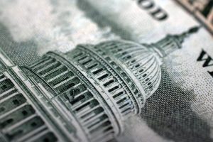 An extreme close-up of a dollar bill showing the dome of the U.S. Capitol