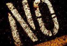 Close-up of the word NO stencil-painted on blacktop